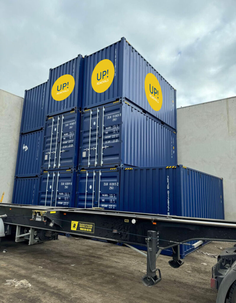 UP! Removals shipping containers stacked at a depot for secure storage and removals logistics