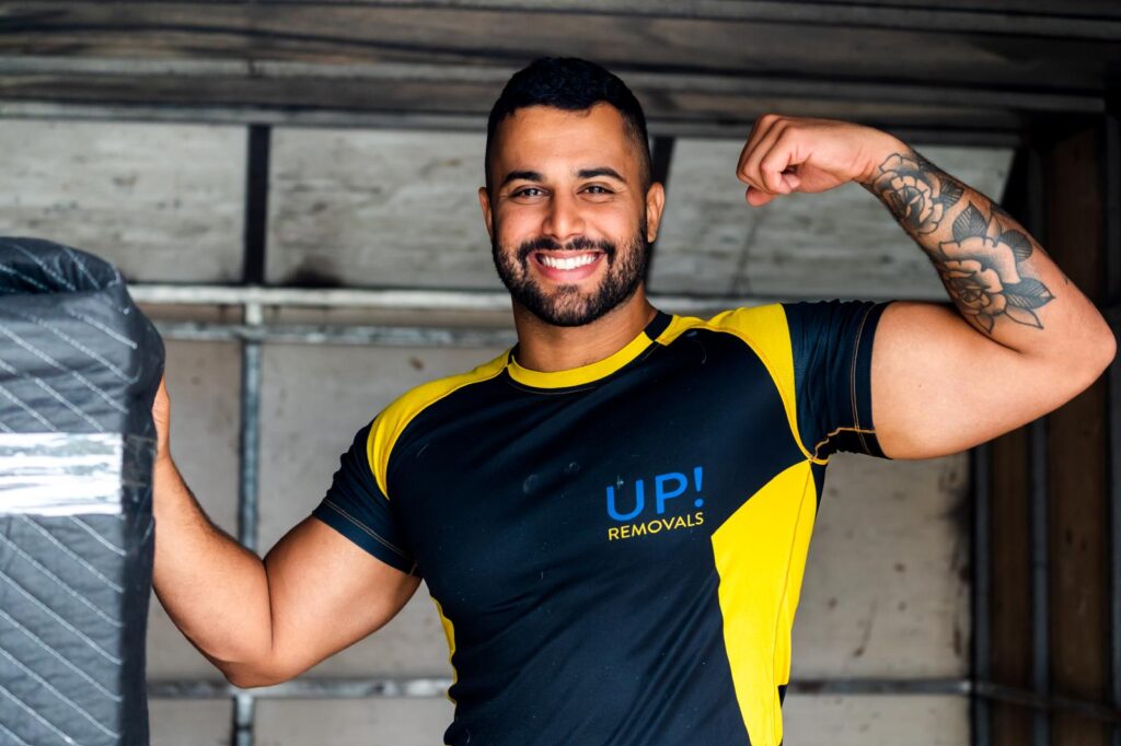 Professional removalist in uniform smiling inside a moving truck during a home relocation in Australia