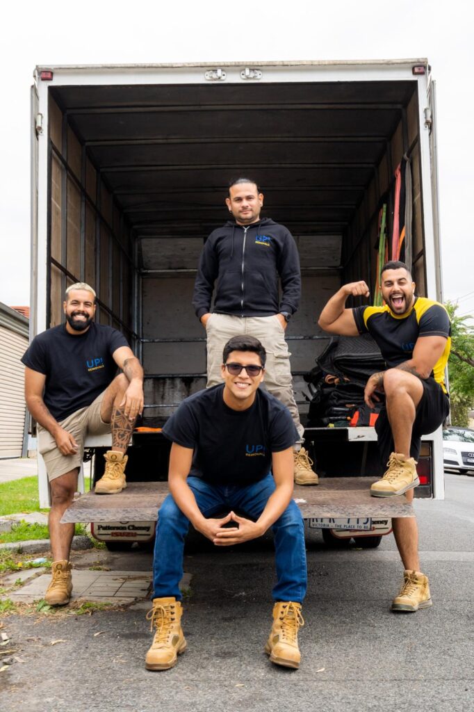 UP! Removals team posing at the back of a moving truck, ready for a house move in Australia