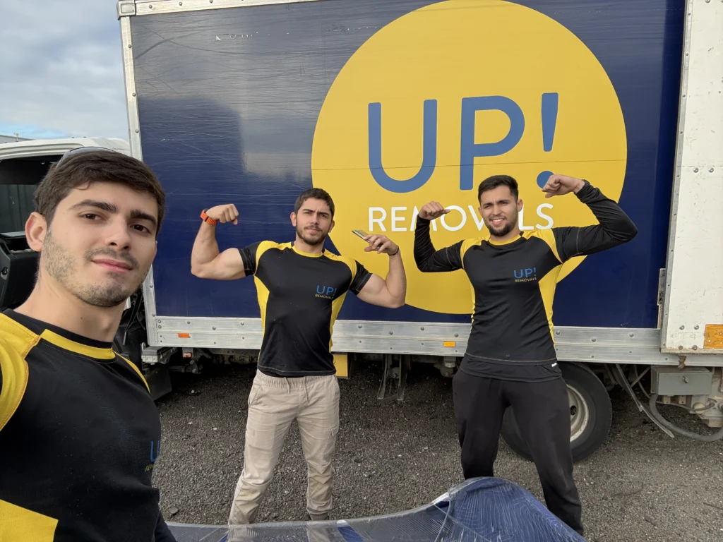 UP! Removals crew in uniform posing in front of an UP! Removals moving truck