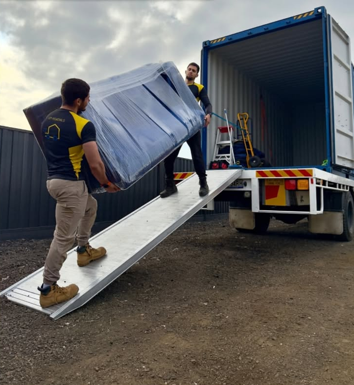 Removalists loading a wrapped mattress up a truck ramp for a safe home relocation in Australia