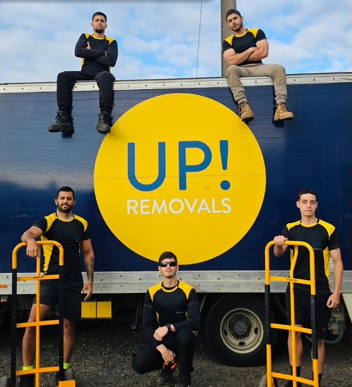 Professional removalists team posing with moving dollies in front of a removal truck in Australia